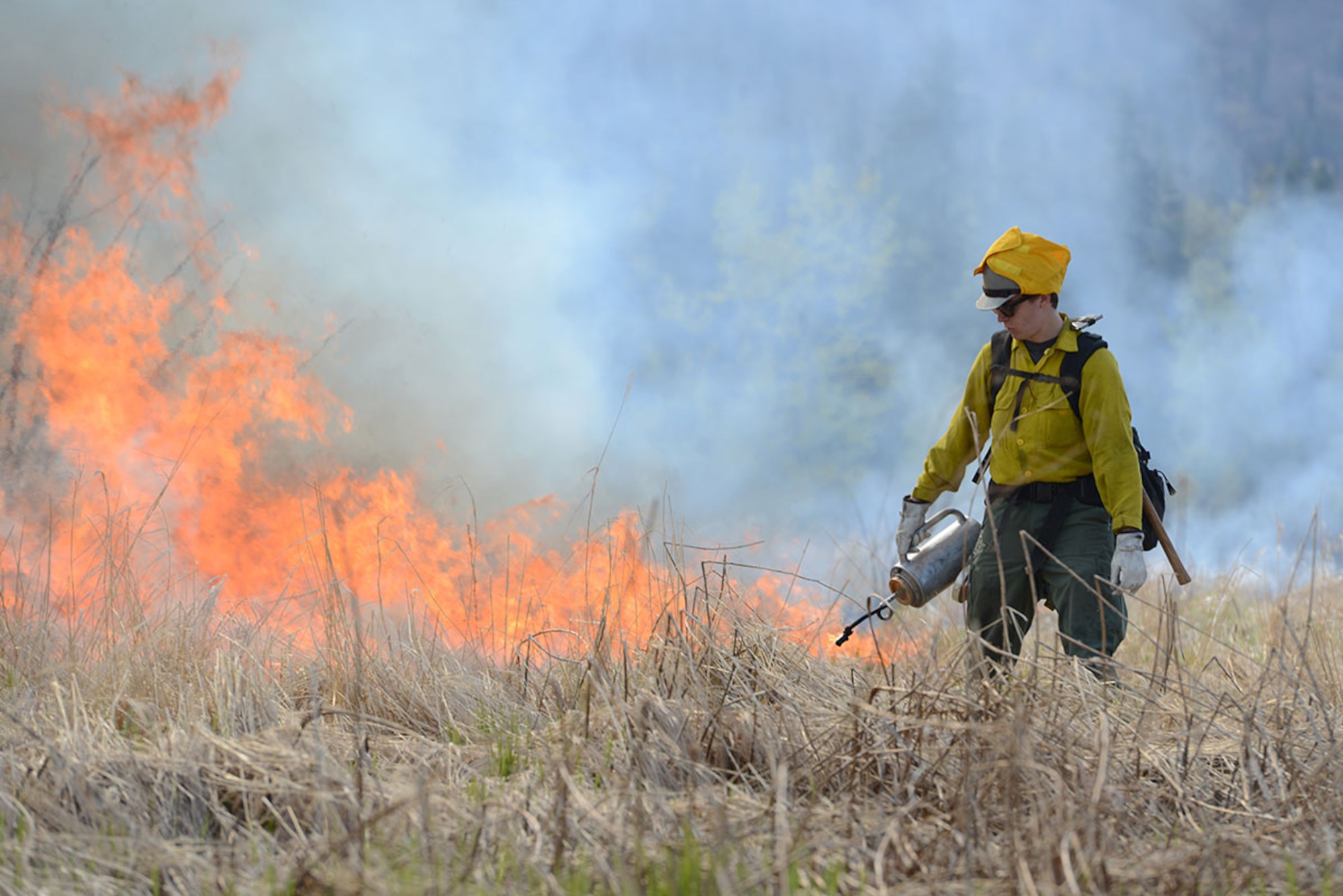 A crewmember with the Alaska Division of Forestry uses a drip torch to burn grass at Grezelka range, Alaska, May 2, 2016. According to the National Oceanic and Atmospheric Administration, last winter in Alaska was the second warmest on record dating back to 1925. Combined with record-low snowfall and precipitation, the chance of fire activity greatly increases as combustible dry detritus accumulates. Controlled burns reduce the chance of spot fires by removing excess dry brush and grass. (U.S. Air Force photo by Airman 1st Class Christopher R. Morales)