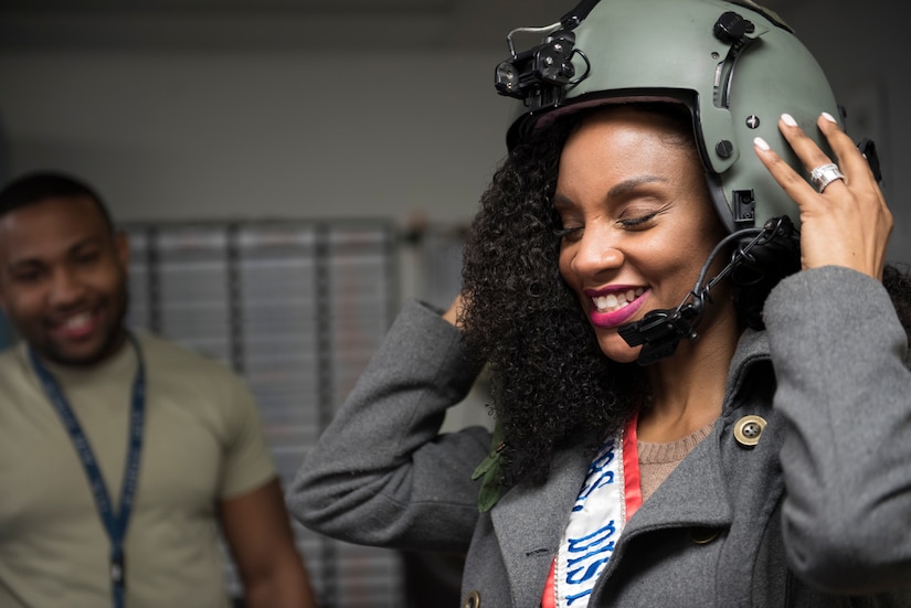 Kinosha Soden, Mrs. DC America and military spouse, tries on a 1st Helicopter Squadron flight helmet during a base tour at Joint Base Andrews, Md., May 11, 2016. Soden spent three years as a member of the DC-based, non-profit organization “Sweethearts for Soldiers,” helping enhance the lives of military men and women. (U.S. Air Force photo by Airman 1st Class Philip Bryant) 