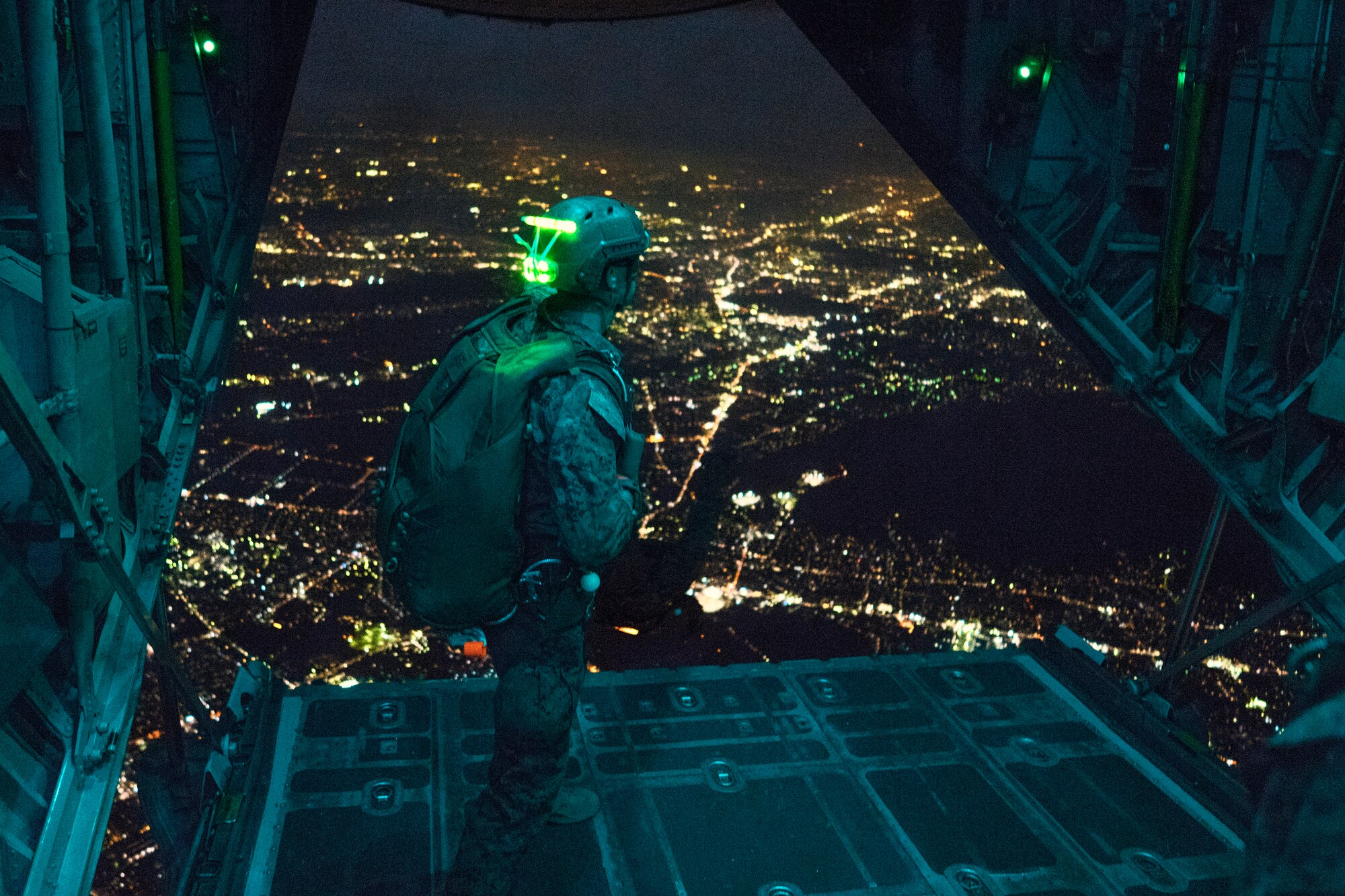 A Marine with the 3rd Marine Division, 3rd Reconnaissance Battalion, observes jumpers over Yokota Air Base, Japan, May 11, 2016. The unit spent the week working on their parachute qualifications practicing static line and high-altitude, low-opening jumps. (U.S. Air Force photo by Senior Airman Delano Scott/Released)