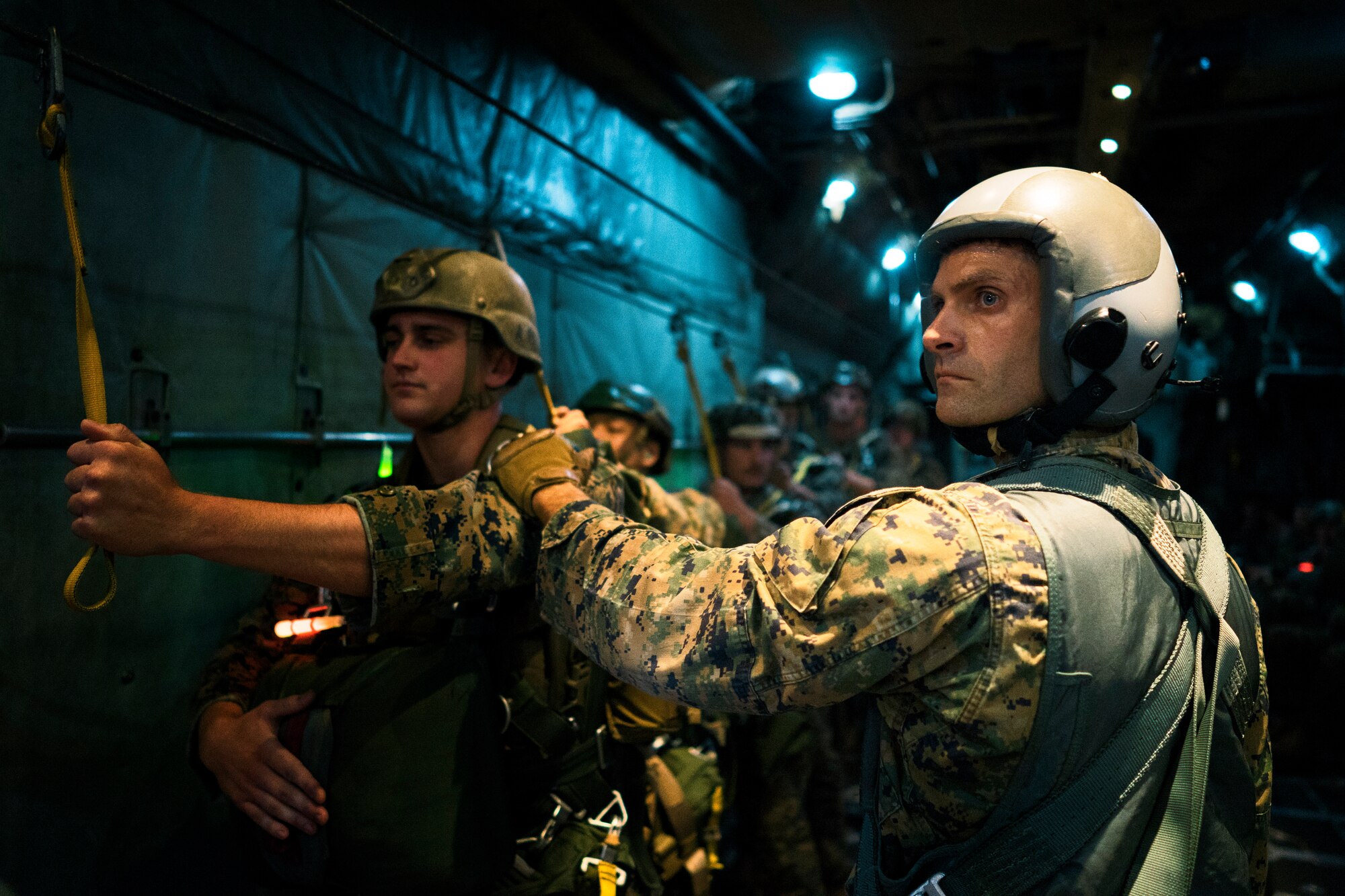 Marines with the 3rd Reconnaissance Battalion, 3rd Marine Division, III Marine Expeditionary Force, prepare to jump out of a C-130 Hercules over Yokota Air Base, Japan, May 11, 2016. The Marines are required to jump at least four times a year to maintain jump qualifications. (U.S. Air Force photo by Senior Airman Delano Scott/Released)