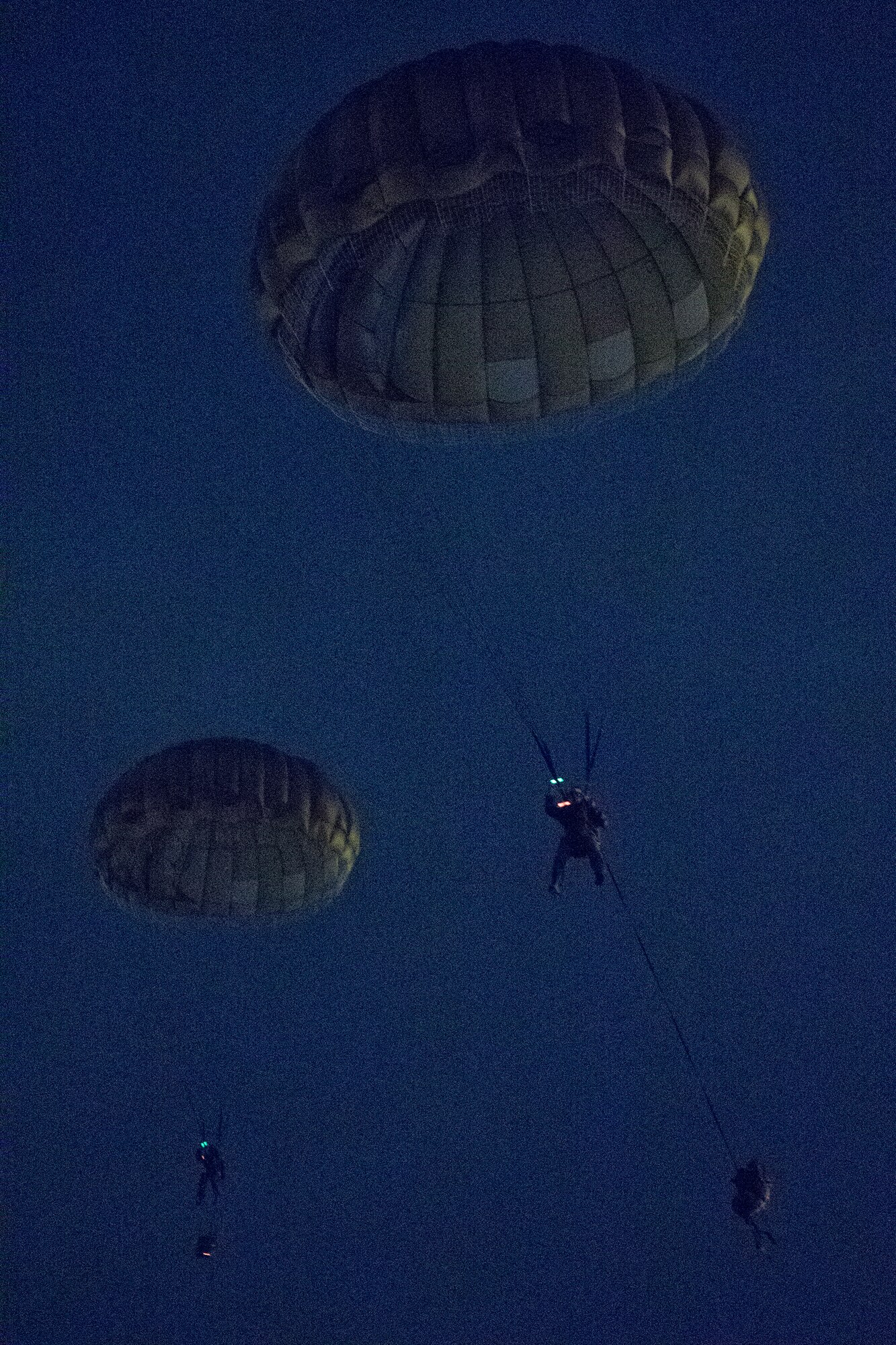 U.S. Marines from the U.S. Marine Corps from the 3rd Reconnaissance Battalion, 3rd Marine Division, III Marine Expeditionary Force descends to the drop zone after exiting from an Air Force C-130 Hercules, assigned to 36th Airlift Squadron, at Yokota Air Base, Japan, May 11, 2016, during Jump week. The training not only allowed the Marines to practice jumping, but it also allowed the Yokota aircrews to practice flight tactics and timed-package drops. (U.S. Air Force photo by Yasuo Osakabe/Released)   