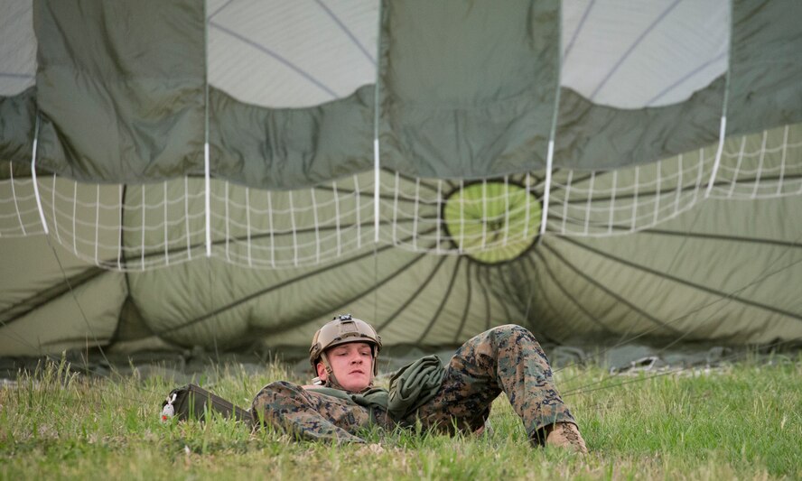 U.S. Marine Cpl. Jacob Zimmerman, 3rd Reconnaissance Battalion, 3rd Marine Division, III Marine Expeditionary Force lands to the drop zone at Yokota Air Base, Japan, May 11, 2016, during Jump week. The training not only allowed the Marines to practice jumping, but it also allowed the Yokota aircrews to practice flight tactics and timed-package drops. (U.S. Air Force photo by Yasuo Osakabe/Released)   