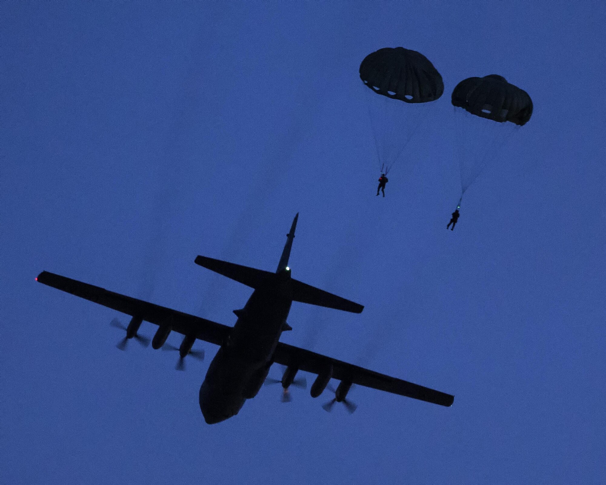 U.S. Marines from the 3rd Reconnaissance Battalion, 3rd Marine Division, III Marine Expeditionary Force drop from a U.S. Air Force C-130 Hercules, assigned to 36th Airlift Squadron at Yokota Air Base, Japan, May 11, 2016 during Jump Week. The training not only allowed the Marines to practice jumping, but it also allowed the Yokota aircrews to practice flight tactics and timed-package drops. (U.S. Air Force photo by Yasuo Osakabe/Released)    