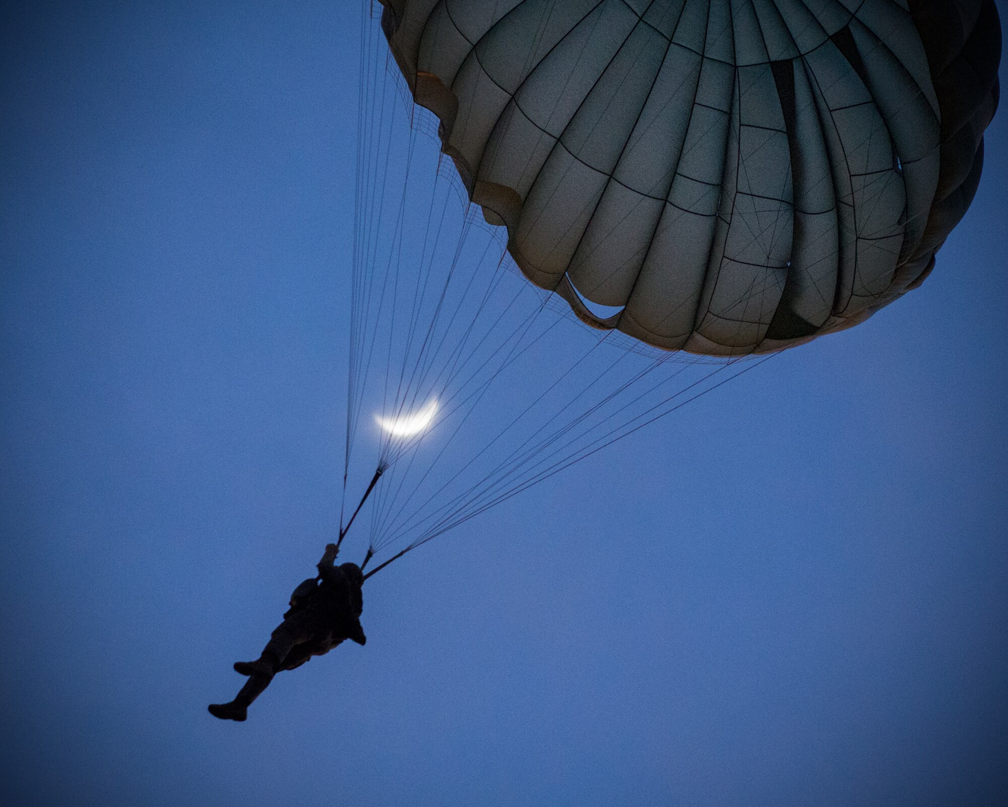 A U.S. Marine from the U.S. Marine Corps from the 3rd Reconnaissance Battalion, 3rd Marine Division, III Marine Expeditionary Force descends to the drop zone after exiting from an Air Force C-130 Hercules, assigned to 36th Airlift Squadron, at Yokota Air Base, Japan, May 11, 2016, during Jump week. The training not only allowed the Marines to practice jumping, but it also allowed the Yokota aircrews to practice flight tactics and timed-package drops. (U.S. Air Force photo by Yasuo Osakabe/Released)    