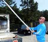 John Carter, Quality Recycling Program yard manager, offloads metal furniture at the base scrap yard. (U.S. Air Force photo by Tommie Horton)
