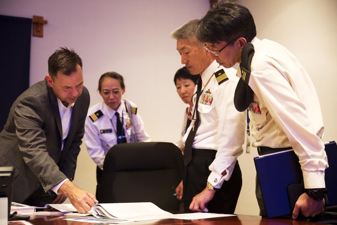 U.S. Marine Corps Lt. Col. Gary W. Thomason, exeutive officer of Marine Corps Air Station Iwakuni, discusses military operations with Japan Ground Self-Defense Force Col. Mitsuhiko Nakadai, Japan Maritime Self-Defense Force Capt. Atsushi Tanaka, JMSDF Capt. Madoka Sato and JMSDF Cmdr. Hiroko Takigawa, instructors from the Japanese Joint Staff College, during their visit to the air station in Iwakuni, Japan, May 9, 2016. The Japanese Joint Staff College instructors visited MCAS Iwakuni to learn about Marine Air-Ground Task Force operations. (U.S. Marine Corps photo by Lance Cpl. Donato Maffin/Released) 
