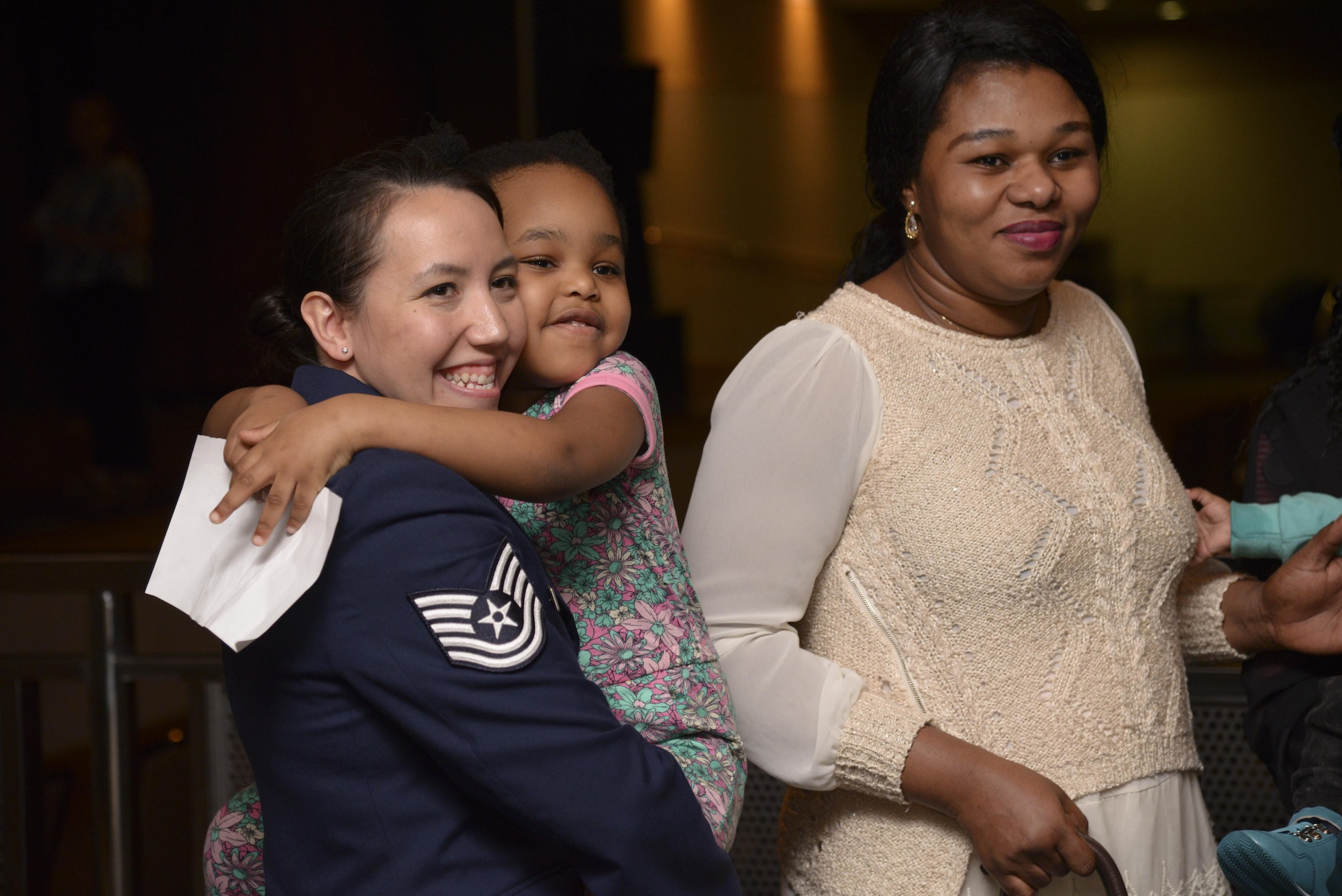 Tech. Sgt. Tina Kay, 607th Weather Squadron, hugs the daughter of Precious Enyioko (right) after the Songtan fire rescue recognition ceremony at Osan Air Base, Republic of Korea, May 13, 2016. Kay was credited with keeping the family safe and administering first aid. Each Airman and Soldier involved with the rescue received an Air Force Commendation Medal and the civilian received a Command Civilian Award For Valor. (U.S. Air Force photo by Tech. Sgt. Travis Edwards)
