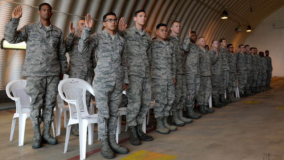 Thirty-two 31st Fighter Wing Airmen raise their right hands and agree to the responsibilities of a Dedicated Crew Chief, May 9, 2016, at Aviano Air Base, Italy. DCCs exemplify technical knowledge, management skills, initiative, and leadership abilities. (U.S. Air Force photo by Airman 1st Class Cary Smith/Released)