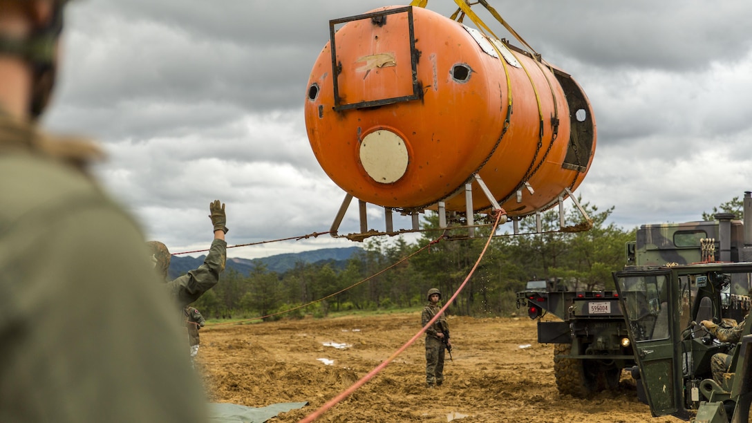 Marines with aircraft rescue and firefighting, Headquarters and Headquarters Squadron, guide a simulated aircraft to the back of a 7-ton medium tactical vehicle replacement during exercise Thunder Horse 16.2 at the Japan Ground Self-Defense Force’s Haramura Maneuver Area in Hiroshima, Japan, May 11, 2016. Motor transportation operators, combat engineers, heavy equipment operators and aircraft rescue and firefighters worked together to recover the simulated downed aircraft. The exercise focuses on reinforcing skills that Marines learned during Marine Combat Training and throughout their military occupational specialty schooling in order to maintain situational readiness. The opportunity to train in this environment helps Marines within different squadrons enhance their technical skills, field experience and military occupational specialty capabilities. 