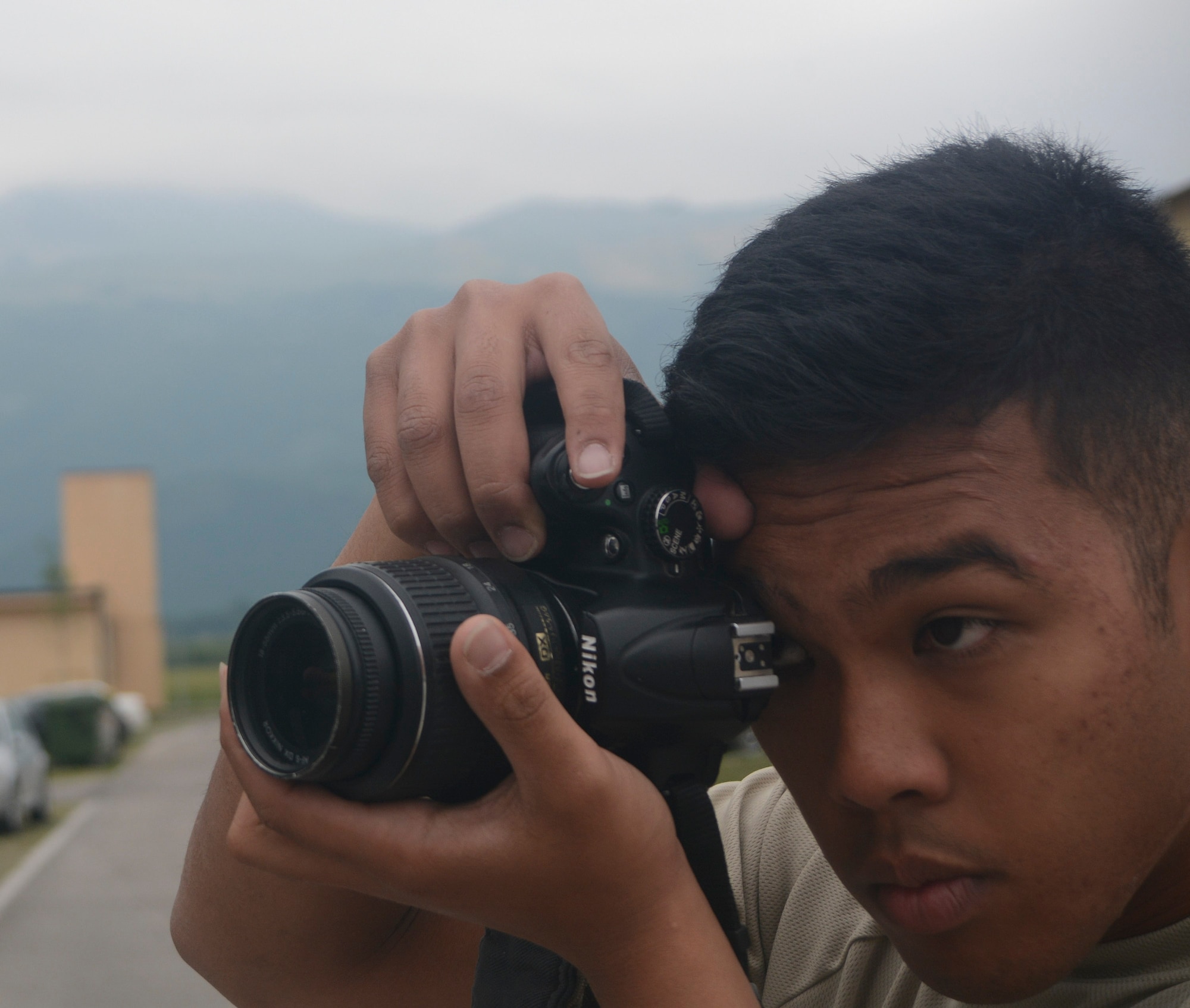Senior Airman Andrew Castro, 71st Aerial Port Squadron, focuses his camera on something that catches his eye May 11, 2016, Aviano Air Base, Italy. Castro is participating in job proficiency enhancement training during his unit’s annual training during the duty day and is photographing his trip during his free time.  (U.S. Air Force photo/Staff Sgt. Joe Yanik)