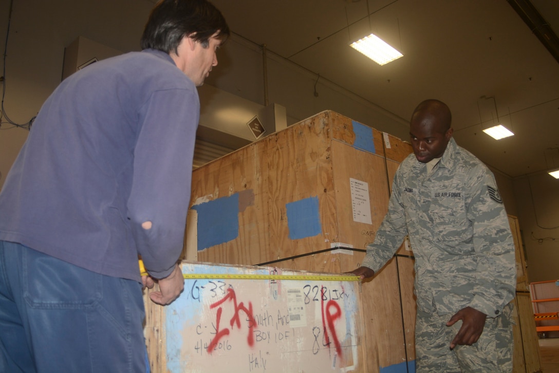 Tech. Sgt. William Jacobs (right), special handling supervisor with the 71st Aerial Port Squadron, discusses measurements of cargo crates with a local Italian employee at the 724th Air Mobility Squadron's Air Freight section, Aviano Air Base, Italy, May 11, 2016. Jacobs and his fellow aerial porters had to overcome language barriers to successfully accomplish daily tasks around the air terminal during his unit's job proficiency enhancement training. (U.S. Air Force photo/Staff Sgt. Joe Yanik)