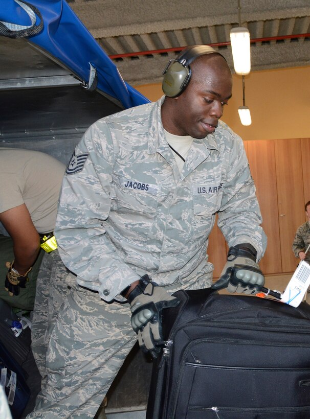 Tech. Sgt. William Jacobs, special handling supervisor with the 71st Aerial Port Squadron, unloads a passenger cargo bin at Aviano Air Base, Italy, May 5, 2016. Jacobs gains hands-on experience while processing passengers for departure during his unit’s job proficiency enhancement tour. (U.S. Air Force photo/Staff Sgt. Joe Yanik)