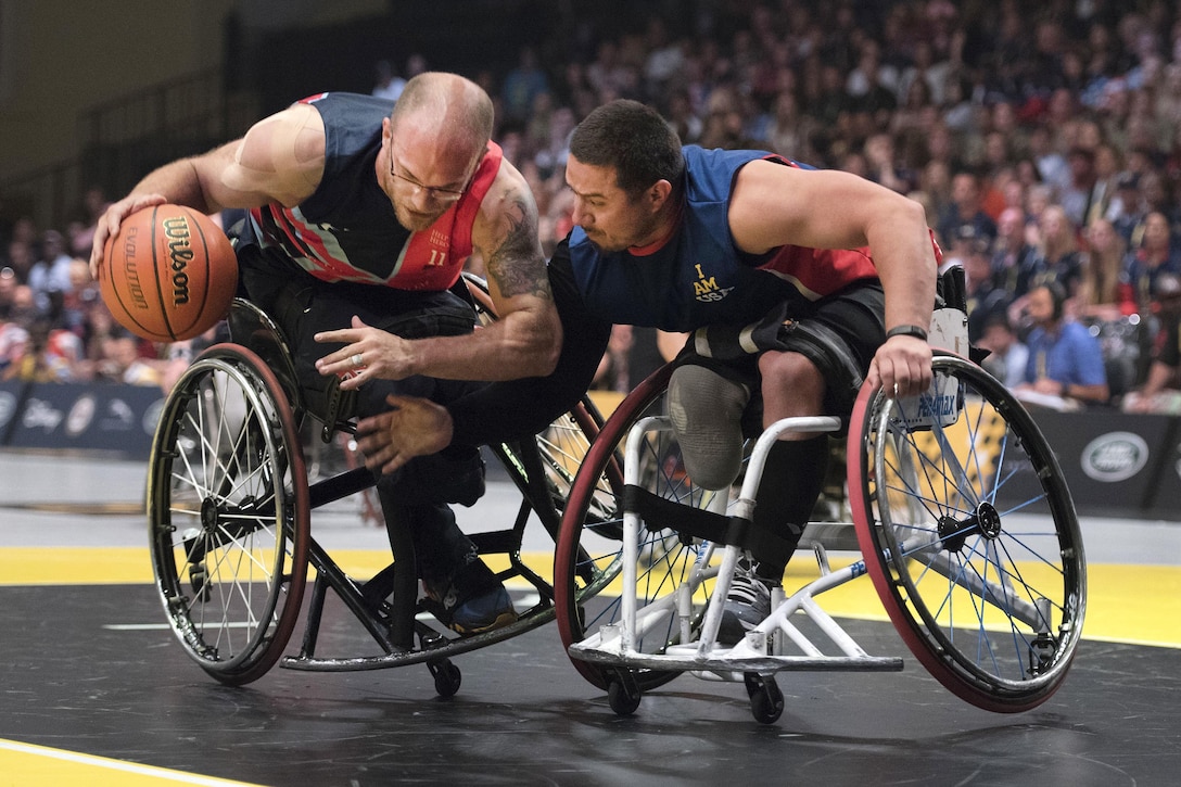Marine Corps veteran Eric Rodriguez, right, scrambles for the ball against Great Britain’s Adam Nixon during the gold medal wheelchair basketball competition at the 2016 Invictus Games in Orlando, Fla., May 12, 2016. Army photo by Sgt. Jason Edwards