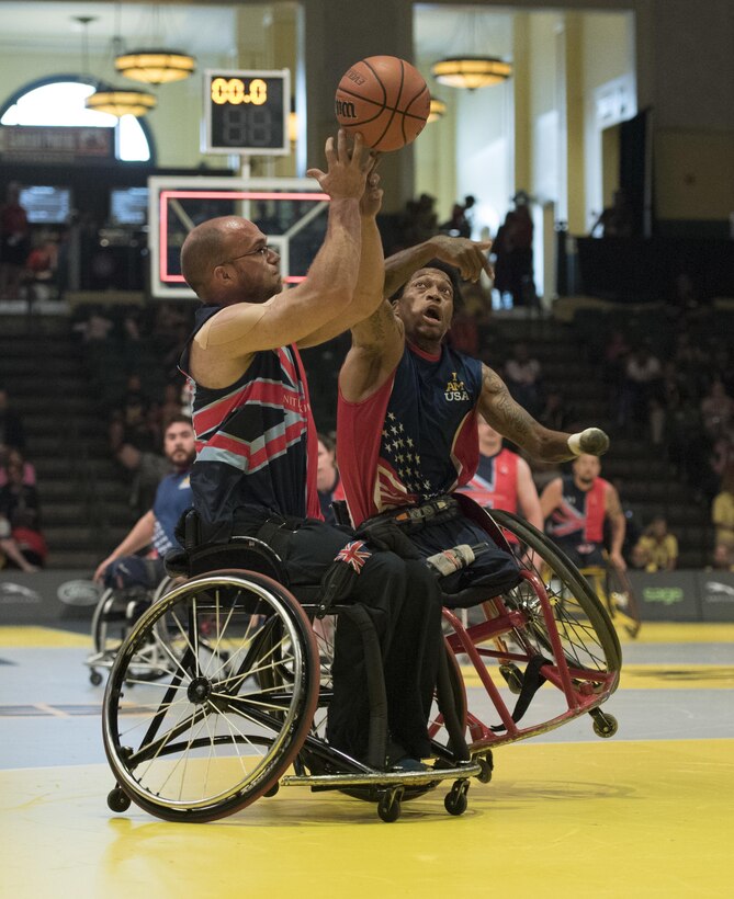 Marine Corps veteran Anthony McDaniel, right, attempts to steal the ball from Great Britain’s Adam Nixon during the gold medal wheelchair basketball competition at the 2016 Invictus Games in Orlando, Fla., May 12, 2016. DoD photo by Roger Wollenberg