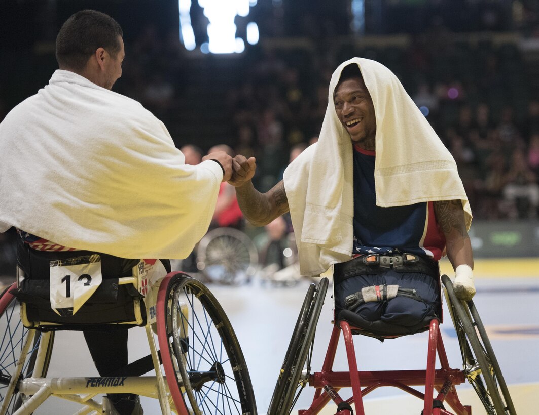 Marine Corps veterans Eric Rodriguez, left, and Anthony McDaniel fist bump as the U.S. team takes a timeout against the British team during the gold medal wheelchair basketball competition at the 2016 Invictus Games in Orlando, Fla., May 12, 2016. DoD photo by Roger Wollenberg