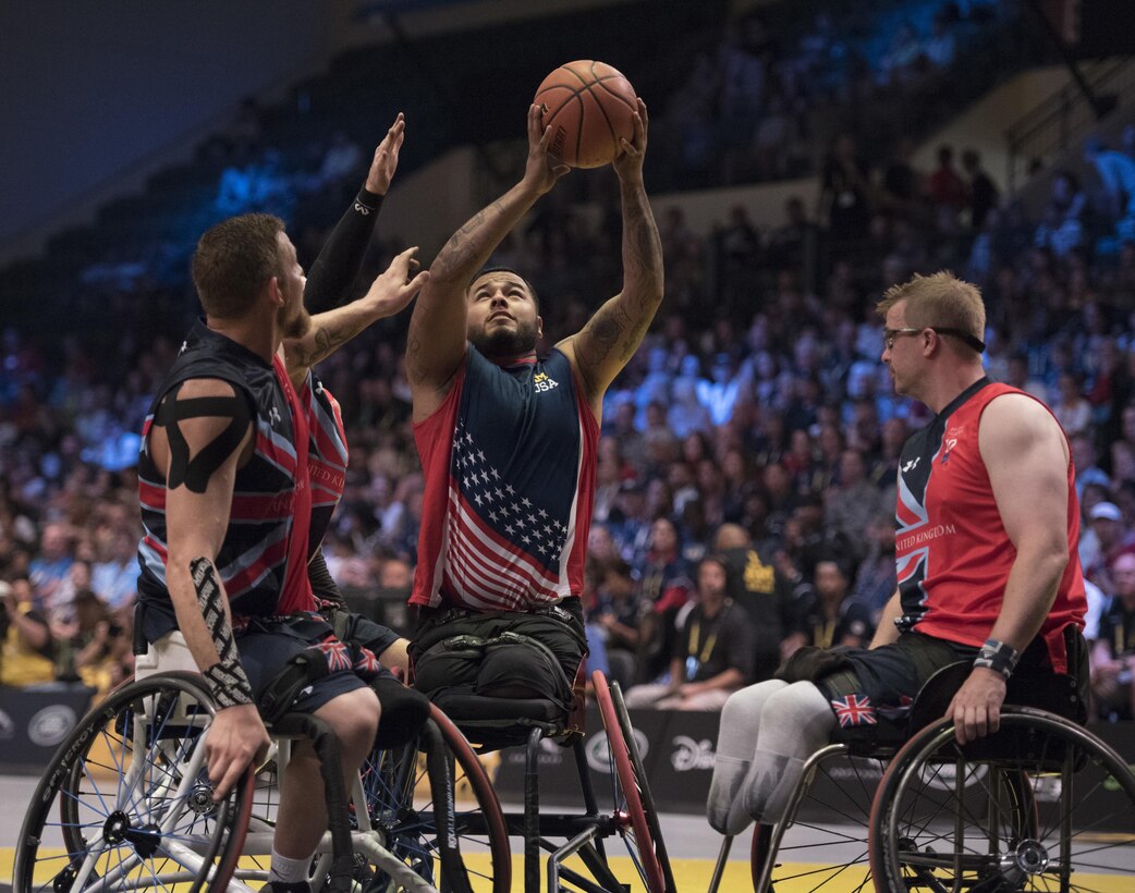 Marine Corps veteran Jorge Salazar, center, prepares to take a shot as three British defenders surround him during the gold medal wheelchair basketball competition at the 2016 Invictus Games in Orlando, Fla., May 12, 2016. DoD photo by Roger Wollenberg 