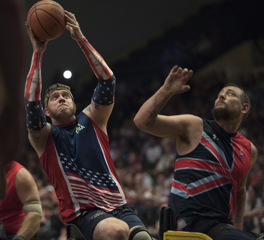 Navy veteran Adam Hygema, left, takes a shot while guarded by a British defender during the gold medal wheelchair basketball competition at the 2016 Invictus Games in Orlando, Fla., May 12, 2016. DoD photo by Roger Wollenberg