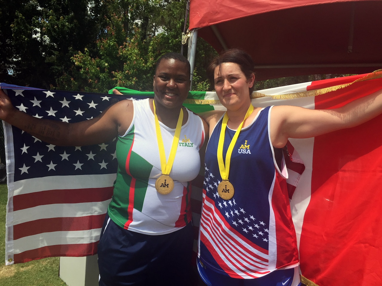 Medically retired Army Sgt. Monica Southall celebrates with 1st Maj. Cpl. Pellegrina Caputo of the Italian army after they both received gold medals in shot put in their respective disability categories during the track and field competition at the 2016 Invictus Games at the ESPN World Wide of Sports Complex at Walt Disney World, Orlando, Fla., May 10, 2016. Caputo asked Southall to trade jerseys to share in the camaraderie of the games, and she happily accepted. DoD photo by Shannon Collins