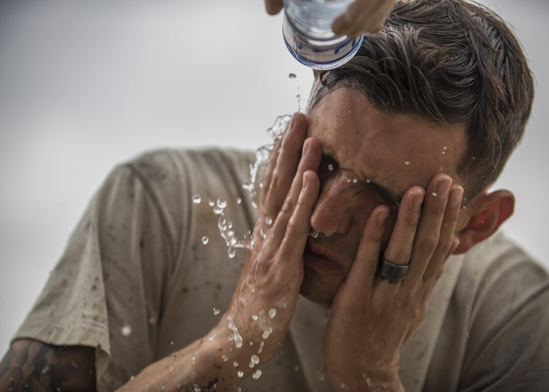 Senior Airman Jacob Nevills, 455th Expeditionary Civil Engineer Squadron Dirt Boy, washes the concrete from his face after helping fill a footer at Bagram Airfield, Afghanistan, May 03, 2016. Members of the 455th ECES are digging out eight trenches to house eight footers for the future placement of four relocatable buildings. (U.S. Air Force photo by Senior Airman Justyn M. Freeman)
