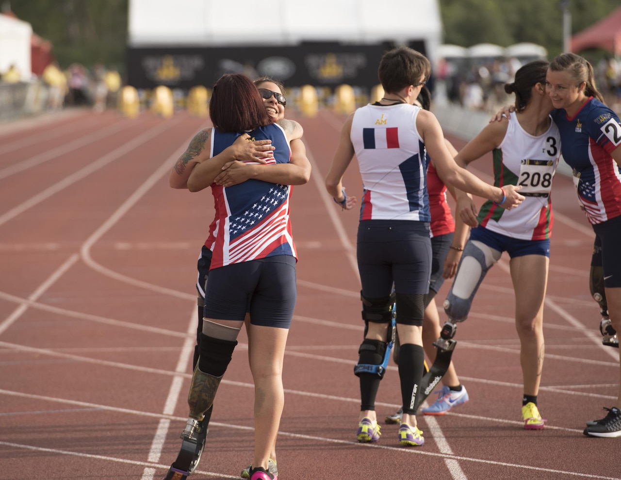 Marine Corps Lance Cpl. Sarah Rudder, U.S. Special Forces Army Staff Sgt. Lauren Montoya, France's Marion Blot, medically retired Army Sgt. Anna Manciaz, Italy's Monica Contrafatto, and Air Force Capt. Christy Wise congratulate each other after running the women's 100-meter dash during the track and field competition at the 2016 Invictus Games at the ESPN Wide World of Sports Complex at Walt Disney World, Orlando, Fla., May 10, 2016. The Invictus Games are the United Kingdom’s version of the Warrior Games, bringing together wounded veterans from 14 nations for events including track and field, archery, wheelchair basketball, road cycling, indoor rowing, wheelchair rugby, swimming, sitting volleyball and a driving challenge. DoD photo by Roger Wollenberg

