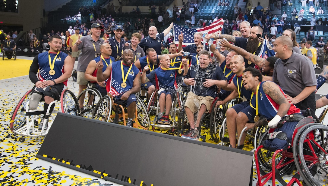 U.S. wheelchair basketball team members douse coach Joey Gugliotta with water while celebrating their gold medal win at the 2016 Invictus Games in Orlando, Fla., May 12, 2016. DoD photo by Roger Wollenberg