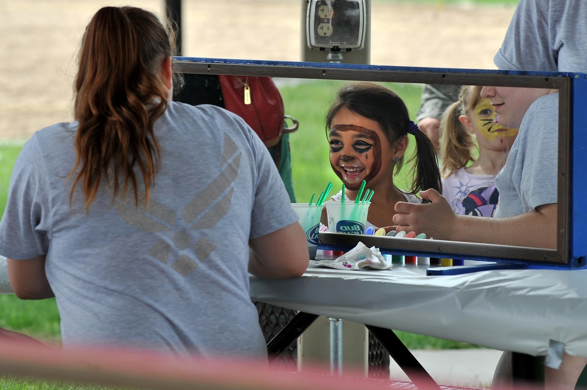 Six-year-old Lynnea, granddaughter of Civil Servant Perry Wilson, takes a glimpse of her face paint June 5 during the Offutt Appreciation Day Picnic held at the Offutt Base Lake. The 2016 OAC picnic is scheduled for June 3. (U.S. Air Force photo by Josh Plueger/Released) 
