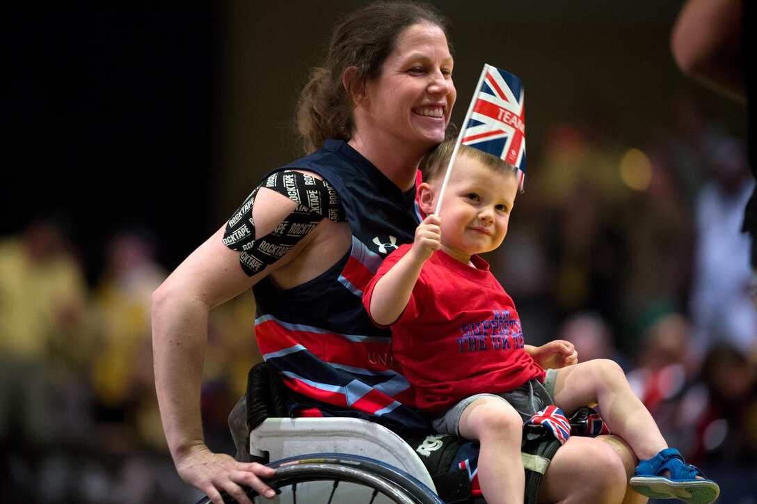 Great Britain Royal Navy Lt. Kirsty Wallace rides off the wheelchair basketball court with her son after her team won a silver medal during the 2016 Invictus Games in Orlando, Fla., May 12, 2016. DoD photo by Edward Joseph Hersom II
