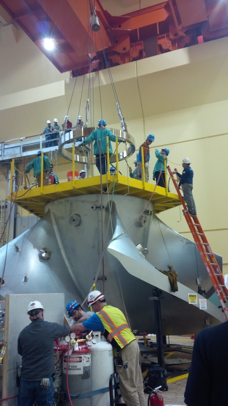 Workers assembling the new high-tech replacement turbine for Ice Harbor’s hydroelectric generator Unit-2 apply heat to expand a metal ring that will lock together the turbine segments from the inside of its hub as the ring cools and shrinks back to normal size. 
