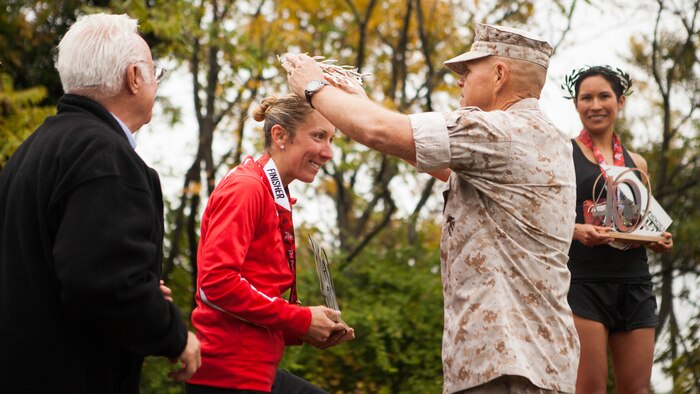 Gen. Robert Neller, commandant of the Marine Corps, presents Capt. Christine Taranto with the second place overall trophy at the 2015 Marine Corps Marathon in Washington, D.C. Taranto, logistics analyst with Marine Corps Systems Command’s Acquisition Logistics and Product Support, was recognized on May 11 as the Marine Corps 2015 Female Athlete of the Year at the Marine Corps Combined Awards Ceremony at Marine Corps Base Quantico, Virginia. (U.S. Marine Corps photo by Sgt. Justin Bolling)