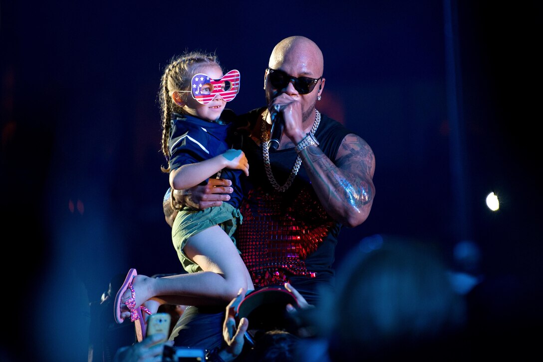 Hip-hop artist Flo Rida holds the 7-year-old daughter of U.S. team member Marine Corps Staff Sgt. Rafael Cervantes while performing at the closing ceremony of the 2016 Invictus Games in Orlando, Fla., May 12, 2016. DoD photo by E. Joseph Hersom