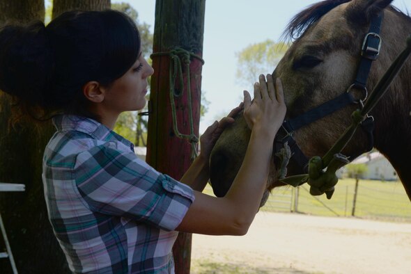 Staff Sgt. Katrina Rubisch, 4th Equipment Maintenance Squadron aircraft armament systems technician, pets her horse, March 24, 2016, in Goldsboro, North Carolina. Rubisch is the president of the Equestrian Club at Seymour Johnson Air Force Base, North Carolina. (U.S. Air Force photo by Airman 1st Class Ashley Williamson/Released)