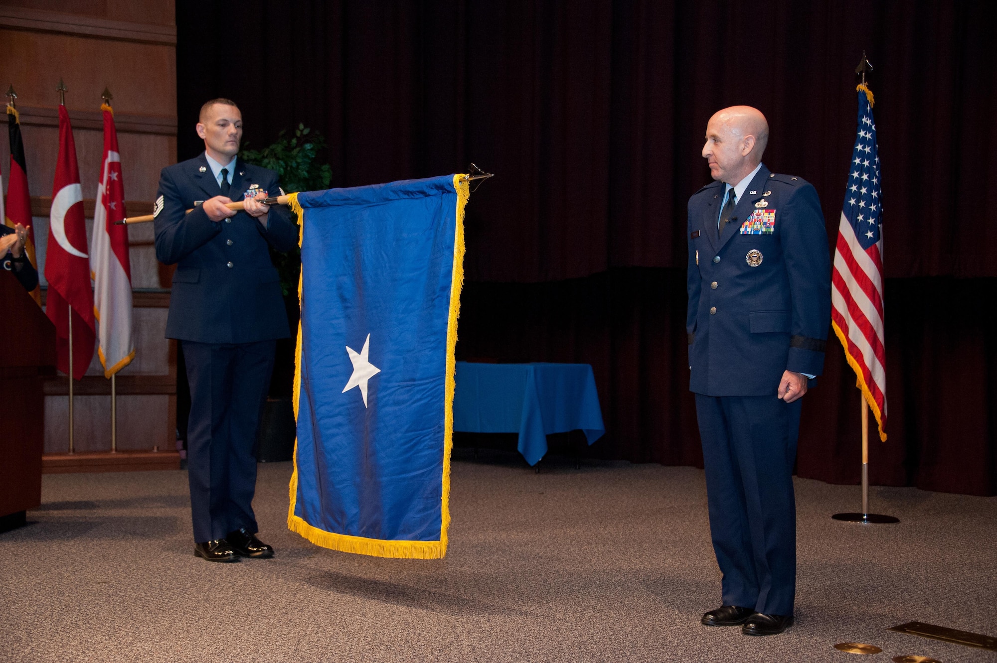 New flag unfurls during Brig. Gen. Edward Thomas promotion ceremony in the Non Commissioned Officer Academy at Maxwell Air Force Base, May 12, 2016.  The term “flag officer” applies to all general officers authorized to fly their own command flags.  (US Air Force photo by Melanie Rodgers Cox) 