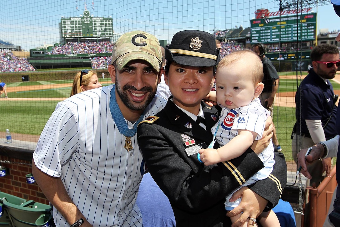 From left to right: Retired U.S. Army Capt. Florent 'Flo' Groberg, Medal of Honor recipient, U.S. Army Reserve 1st Lt. Jiaru Bryar, 85th Support Command, with her 10-month-old, Mason, pause for a photo together during the Chicago Cubs vs Washington Nationals Mothers Day game at Wrigley Field, May 8, 2016. Bryar and Groberg were both honored during the game in front of more than 37,500 in attendance.
(Photo by Sgt. 1st Class Anthony L. Taylor)