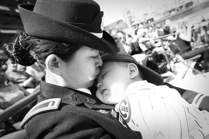 1st Lt. Jiaru Bryar, 85th Support Command, kisses her 10-month-old son, Mason, on the head before stepping out onto the field at the Chicago Cubs' Mother Day game at Wrigley Field, May 8, 2016. Bryar threw out the ceremonial first pitch before the game and was recognized on the field during the fourth inning in front of 37,500 spectators.
(Photo by Sgt. 1st Class Anthony L. Taylor)