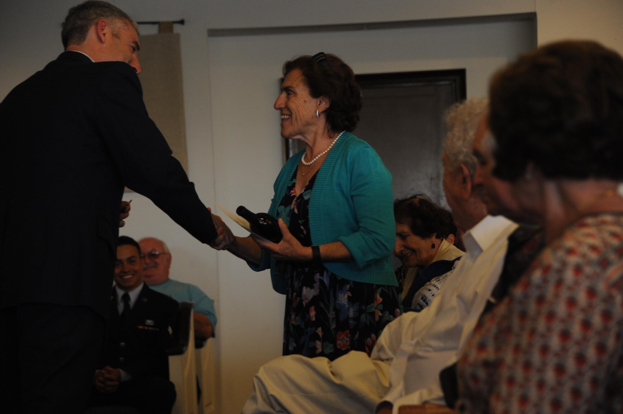 Theresa Dulgov, Holocaust survivor, is presented with a memento of appreciation from Col. Steven Renner, 355th Fighter Wing vice commander, during the Holocaust Day of Remembrance at Davis-Monthan Air Force Base, Ariz., May 9, 2016. Eight Holocaust survivors spoke to Airmen and family members about their personal accounts of survival during the holocaust. (U.S. Air Force photo by Airman Nathan H. Barbour)