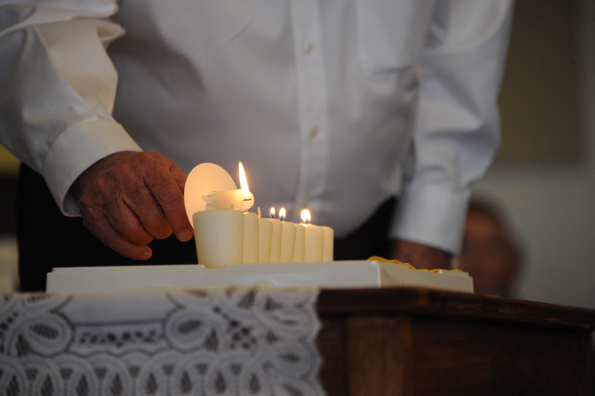 A Holocaust survivor lights a candle during the Holocaust Day of Remembrance at Davis-Monthan Air Force Base, Ariz., May 9, 2016. Dessert lightning team members were invited to listen to holocaust survivors’ personal stories and participate in a candle lighting ceremony to remember those who were lost. (U.S. Air Force photo by Airman Nathan H. Barbour)