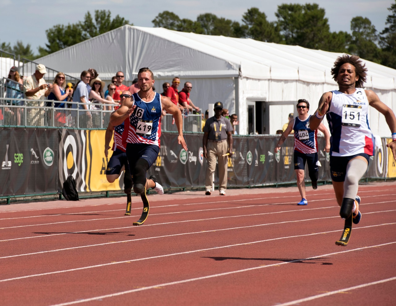 Air Force Staff Sgt. Gideon Connelly and France's Michael Mayali sprint to the finish to medal in the men's 200-meter dash during the track and field competition at the Invictus Games at the ESPN Wide World of Sports complex at Walt Disney World in Orlando, Fla., May 10, 2016. Mayali earned the silver medal, and Connelly took the bronze medal. DoD photo by Roger Wollenberg