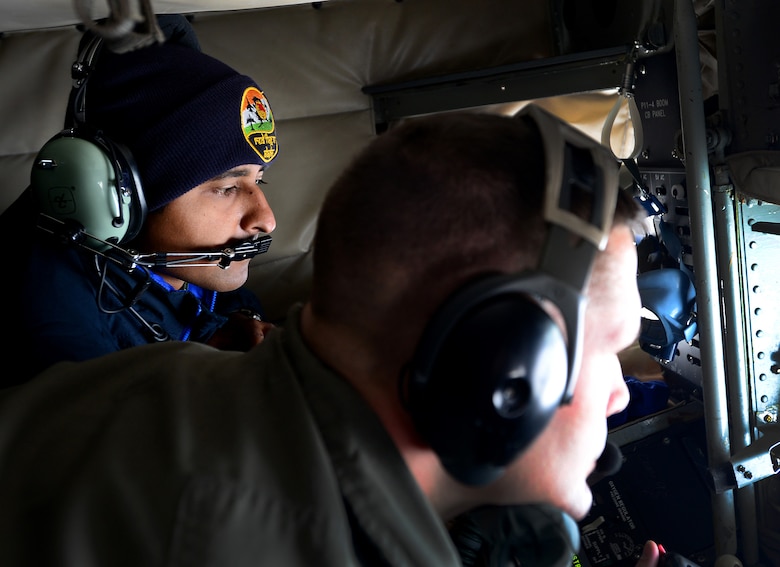 U.S. Air Force Senior Master Sgt. Doug Palmisano, a boom operator with the 909th Air Refueling squadron, Kadena Air Base, Japan, refuels an aircraft while an Indian Air Force (IAF) airman watches during an incentive flight May 10, 2016, over the skies of Alaska. Ten IAF airmen were able to view U.S. Air Force F-16 Fighting Falcon aircraft being refueled. (U.S. Air Force photo by Airman 1st Class Cassandra Whitman)