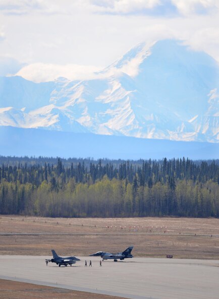 A U.S. Air Force F-16 Fighting Falcon assigned to the 80th Fighter Squadron out of Kunsan Air Base, Republic of Korea, waits at the end of the Eielson Air Force Base, Alaska, flight line with an 18th Aggressor Squadron F-16 nearby May 6, 2016, in preparation for a RED FLAG-Alaska (RF-A) 16-1 mission. RF-A is a series of Pacific Air Forces commander-directed field training exercises for U.S. and partner nation forces, enabling joint and international units to sharpen their combat skills by flying simulated combat sorties in a realistic threat environment inside the Joint Pacific Alaska Range Complex, the largest instrumented air, ground and electronic combat training range in the world. (U.S. Air Force photo by Master Sgt. Karen J. Tomasik/Released)
