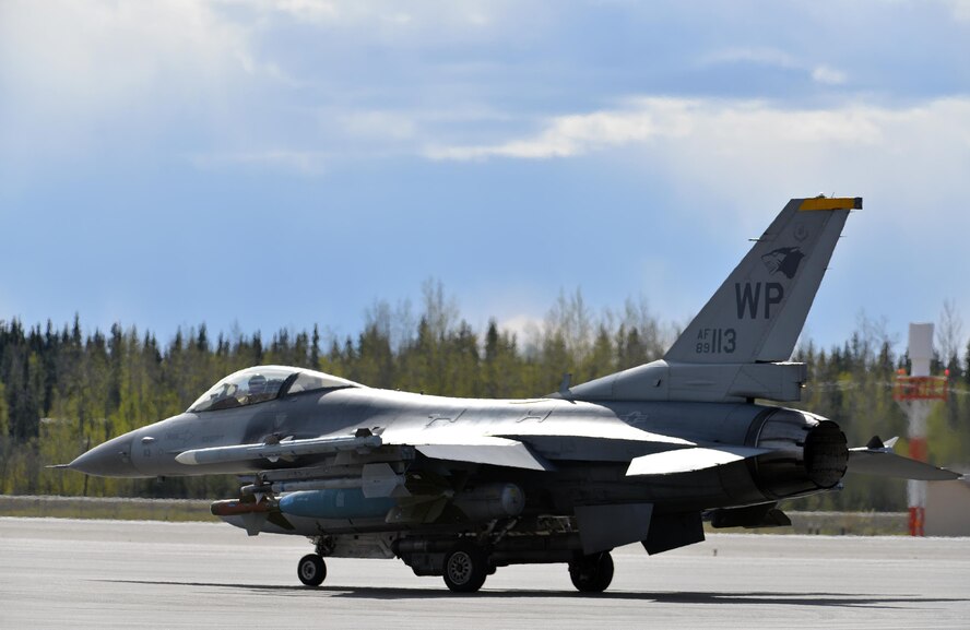A U.S. Air Force F-16 Fighting Falcon pilot assigned to the 80th Fighter Squadron out of Kunsan Air Base, Republic of Korea, taxis down the Eielson Air Force Base, Alaska, flight line May 5, 2016, in preparation for a RED FLAG-Alaska (RF-A) 16-1 afternoon mission. The Joint Pacific Alaska Range Complex provides units like the Wolf Pack access to a realistic training environment and allows commanders to train for full spectrum engagements ranging from individual skills to complex, large-scale joint engagements. (U.S. Air Force photo by Master Sgt. Karen J. Tomasik/Released)