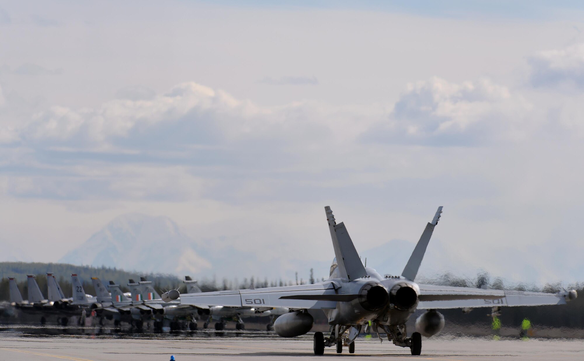 A U.S. Navy EA-18G Growler assigned to Electronic Attack Squadron 137 out of Whidbey Island, Wash., taxis toward U.S. Air Force F-16 Fighting Falcons with the 80th Fighter Squadron from Kunsan Air Base, Republic of Korea, and F-15 Eagles out of Kadena Air Base, Japan, and Indian Air Force Jaguar aircraft from the 14th Squadron, Ambala Air Base, India, at the end of the Eielson Air Force Base, Alaska, flight line May 5, 2016, during RED FLAG-Alaska (RF-A) 16-1. RF-A is a series of Pacific Air Forces commander-directed field training exercises for U.S. and partner nation forces, enabling joint and international units to sharpen their combat skills by flying simulated combat sorties in a realistic threat environment inside the Joint Pacific Alaska Range Complex, the largest instrumented air, ground and electronic combat training range in the world. (U.S. Air Force photo by Master Sgt. Karen J. Tomasik/Released)
