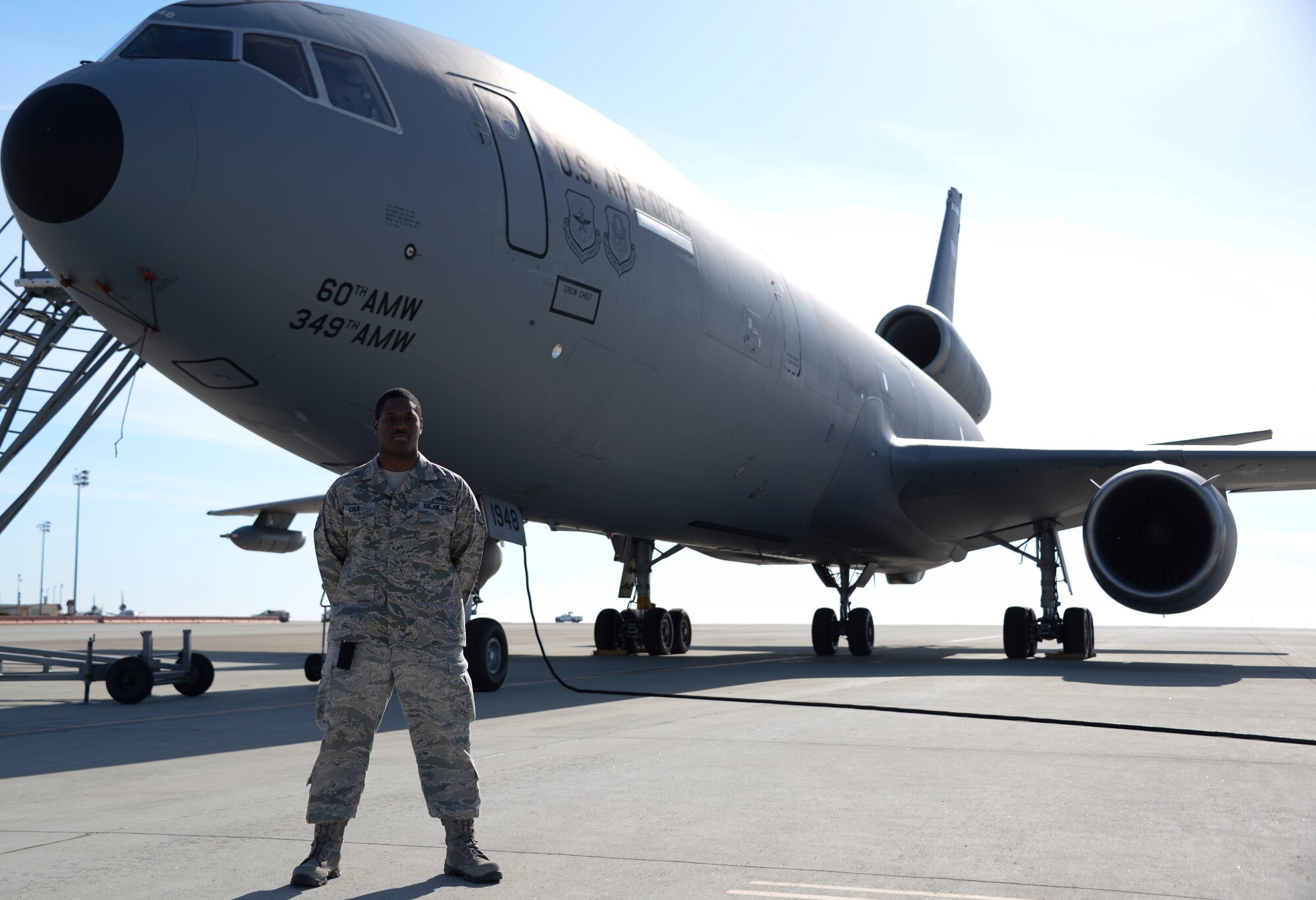 Staff Sgt. Terrell Cole, 660th Aircraft Maintenance Squadron communication/navigation mission systems craftsman, poses for a photo in front of a KC-10 Extender May 11 at Travis Air Force Base, Calif. (U.S. Air Force photo by Senior Airman Amber Carter)