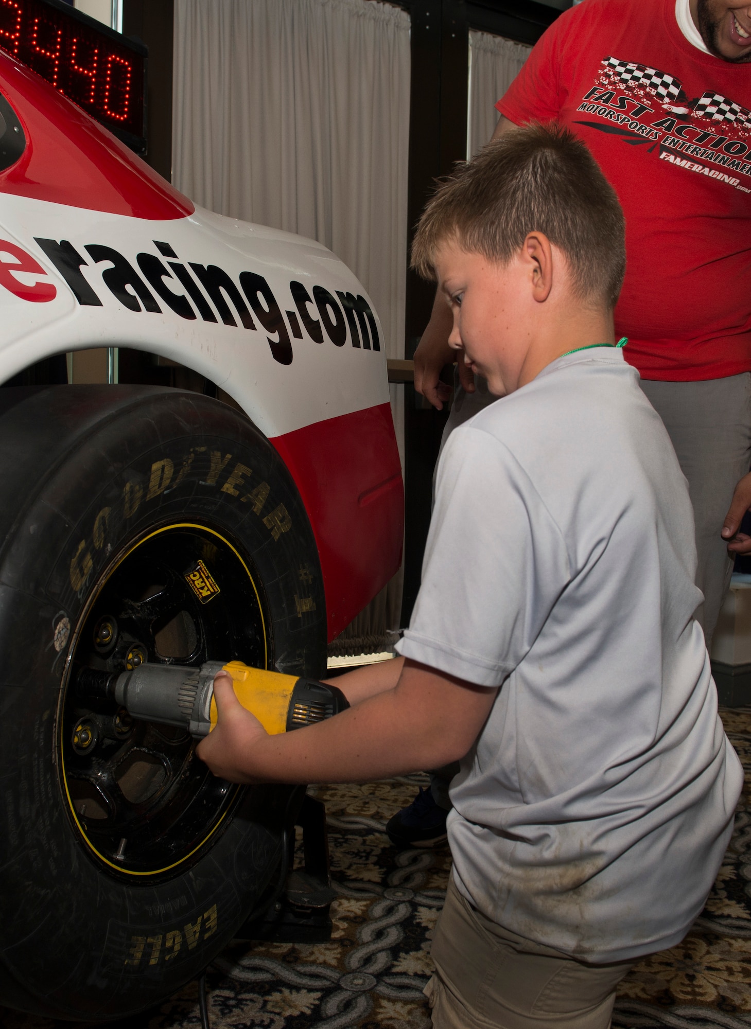 Austin Morrison, son of Master Sgt. Matthew Morrison, 436th Aircraft Maintenance Squadron Support Flight chief, simulates changing a stock car tire May 13, 2016, at the Dover Air Force Base Race Weekend Social at the Landings on Dover AFB, Del. More than $19,000 worth of prizes were given out at the event. (U.S. Air Force photo/Senior Airman Zachary Cacicia)
