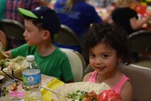 Children of a McChord Airman eat during the Team McChord Deployed Families Dinner at the Chapel Support Center at Joint Base Lewis-McChord, Wash., May 10, 2016. The children enjoyed a catered meal, prizes, toys and even a piñata. (U.S. Air Force photo/Staff Sgt. Naomi Shipley)