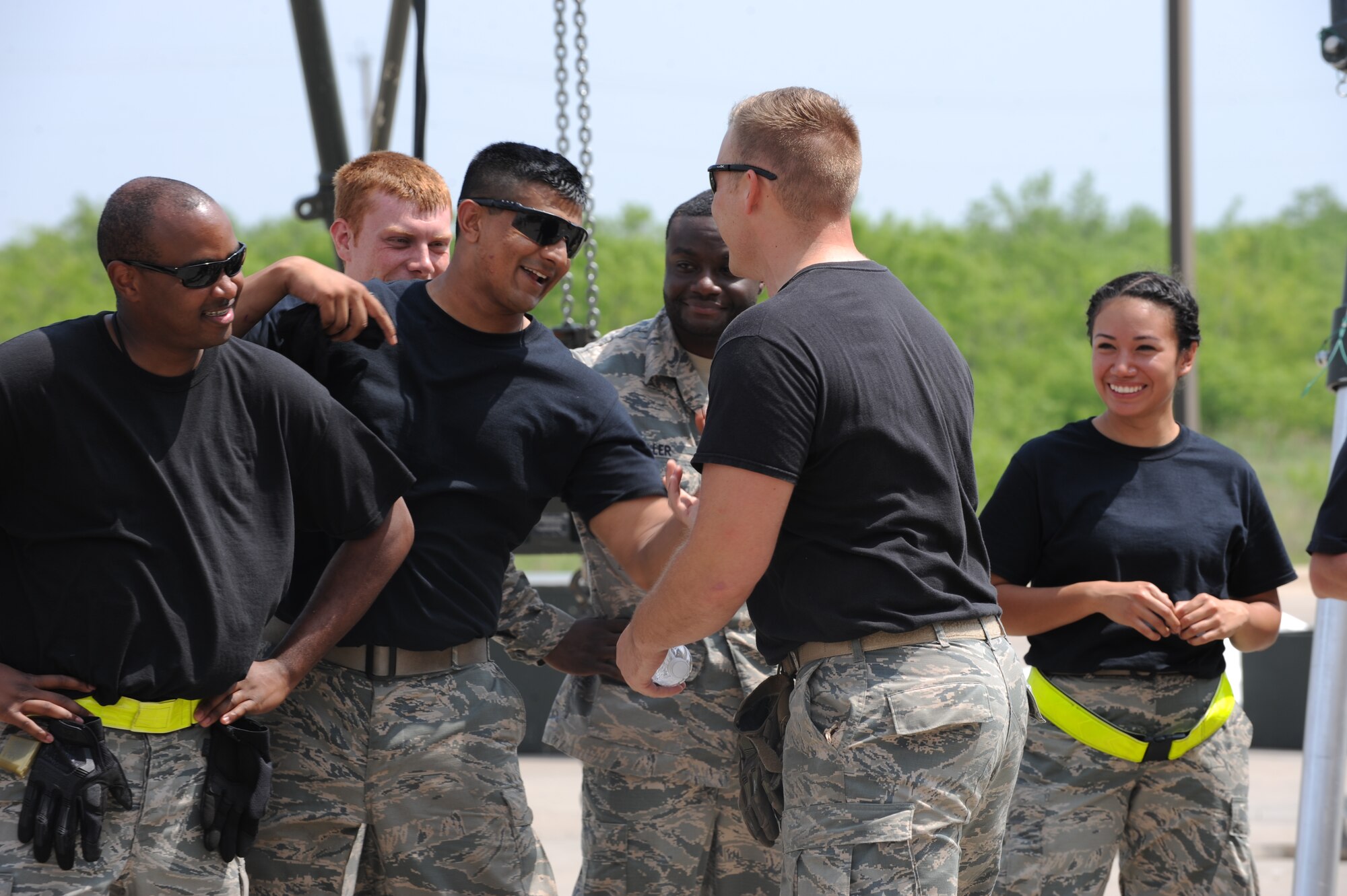 U.S. Air Force Airmen assigned to the 7th Munitions Squadron congratulate one another after a bomb build competition April 29, 2016, at Dyess Air Force Base, Texas. The competition served to improve the technical ability of all participating Airmen as well as act as a platform for multiple sections of the 7th MUNS to showcase their talents. (U.S. Air Force photo by Airman 1st Class Rebecca Van Syoc/Released)