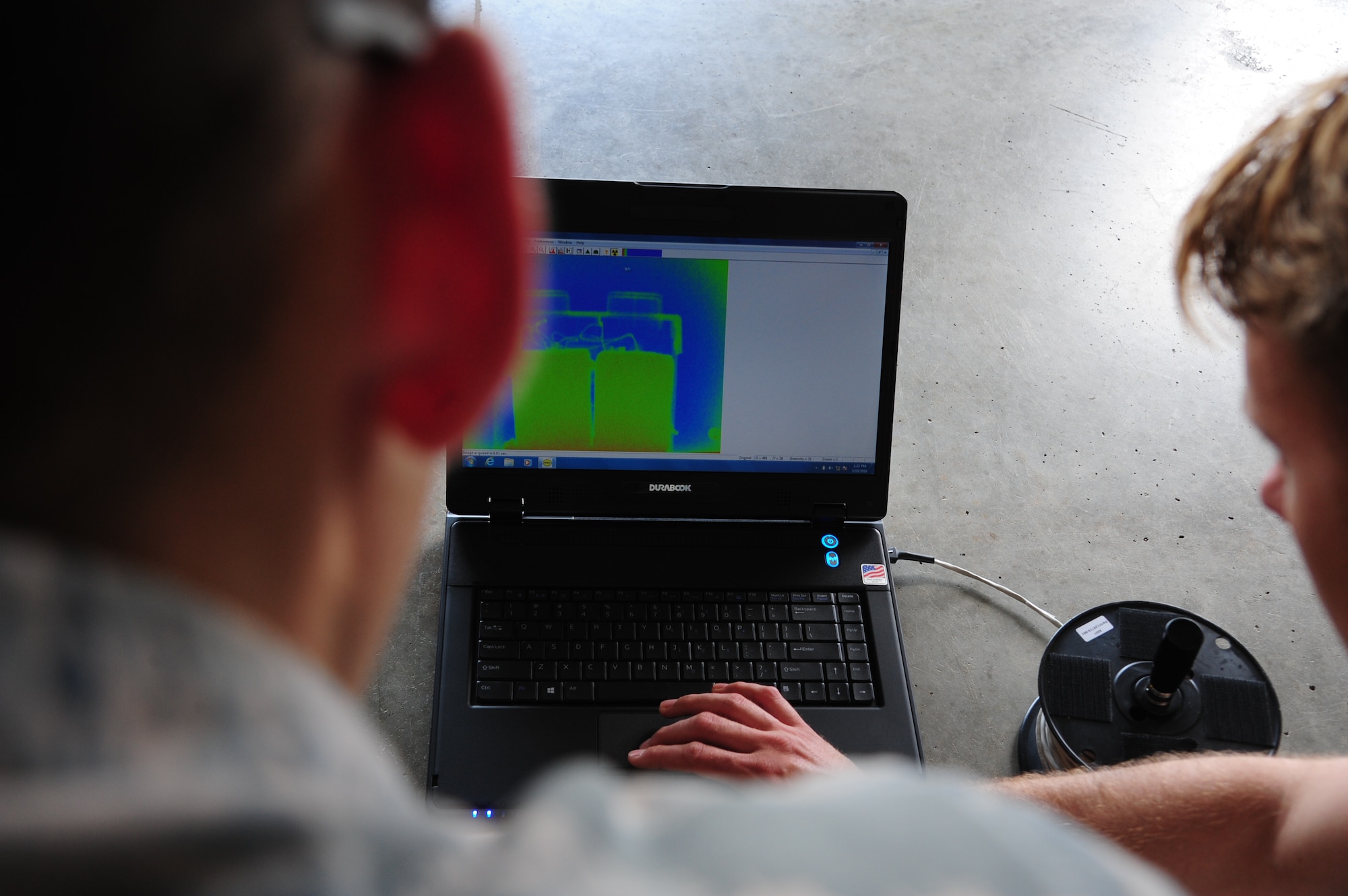 U.S. Air Force Airman 1st Class Matthew Cline, left, and Senior Airman Ryan Carel, both 509th Civil Engineer Squadron explosive ordnance disposal team members, examine an x-ray of a suspicious package at Whiteman Air Force Base, Mo., May 10, 2016. The x-ray is used to reveal the presence of any explosive ordnance within a suspicious package. (U.S. Air Force photo by Airman 1st Class Keenan Berry)