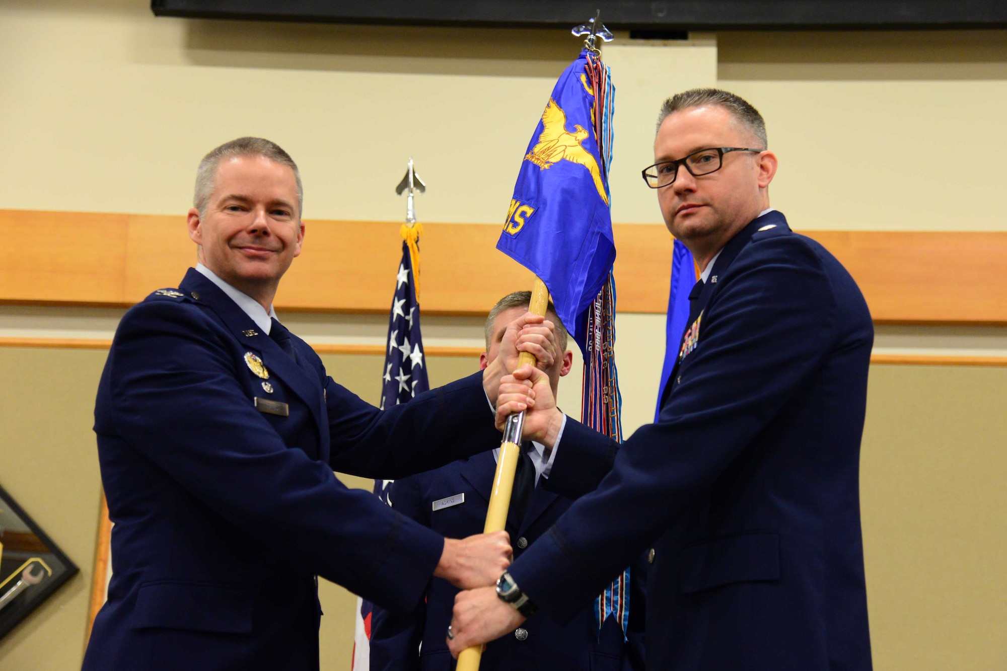 Lt. Col. Daniel Hays, right, accepts command of the 12th Missile Squadron from Col. Glenn Hillis, 341st Operations Group commander, during a change of command ceremony at the Grizzly Bend at Malmstrom Air Force Base, Mont., May 13, 2016. Master Sgt. Timothy Adkins, 12th MS superintendent, looks on. (U.S. Air Force photo/Airman 1st Class Magen M. Reeves)