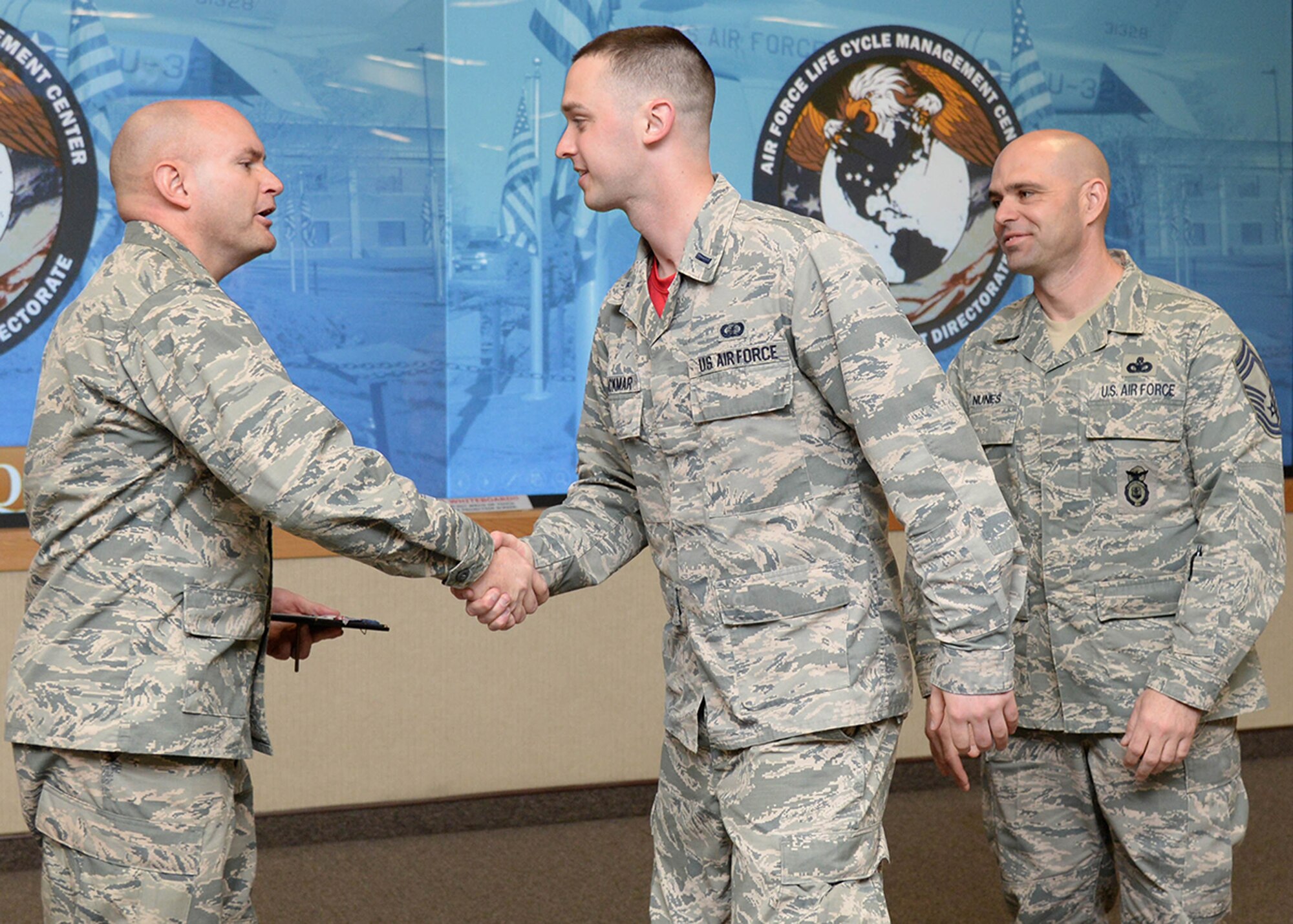 Col. David R. Dunklee, installation commander, congratulates 1st Lt. John M. Blackmar, named the Company Grade Officer of the quarter, during the Team Hanscom quarterly awards ceremony at the Hanscom Conference Center May 13. At the event, more than 45 nominees from the 319th Recruiting Squadron, 66th Air Base Group, Battle Management, C3I and Networks, Joint Personal Property Shipping Office, Air Force Nuclear Weapons Center and Contracting were recognized along with the winners. (U.S. Air Force photo by Linda LaBonte Britt)