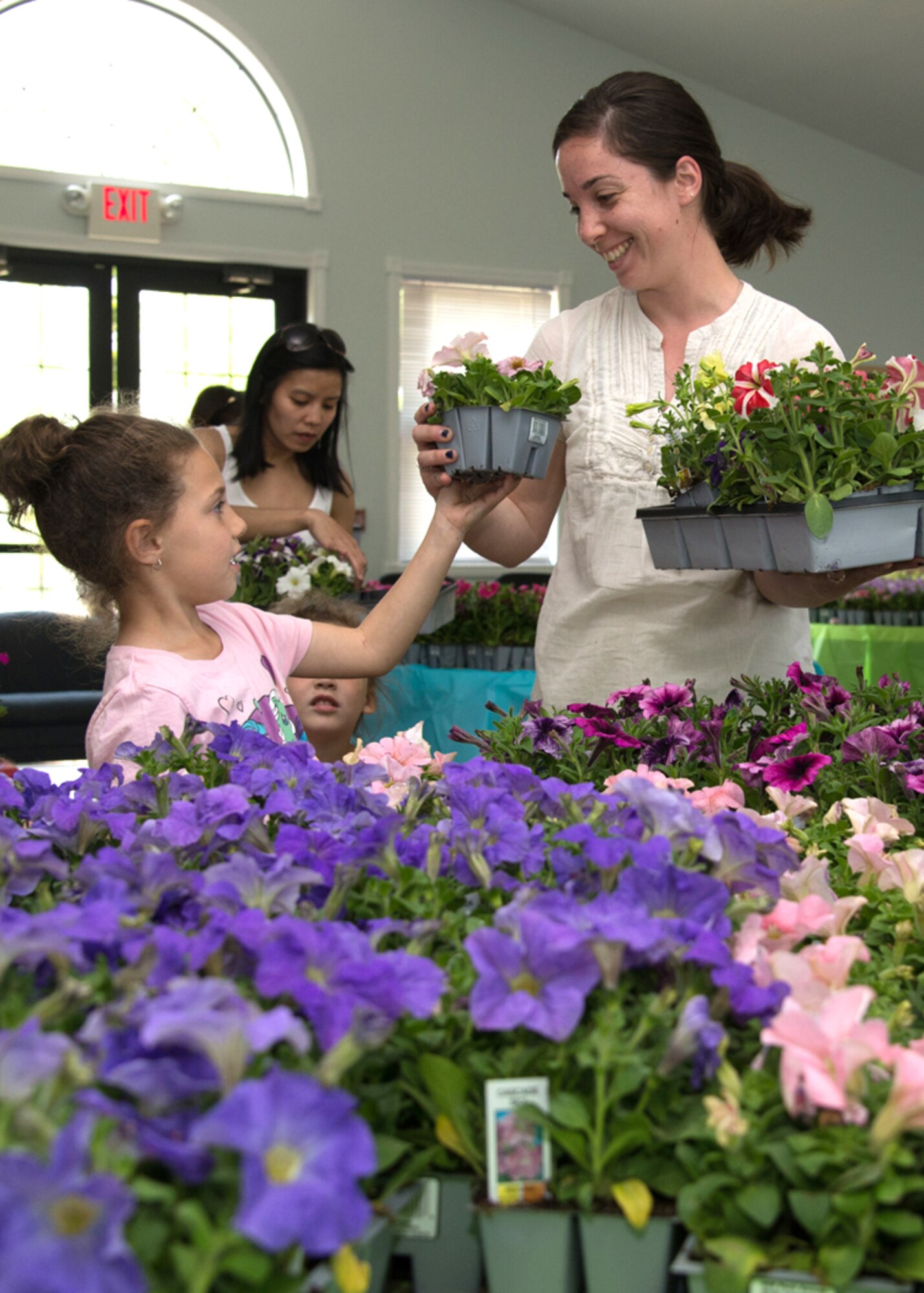 Amanda Underwood, and daughters, Marley and Emely, choose flowers at the housing community center May 12. Hanscom Family Housing hosted their annual flower giveaway and invited residents to pick up flowers to plant around their housing units. (U.S. Air Force photo by Walter Santos)