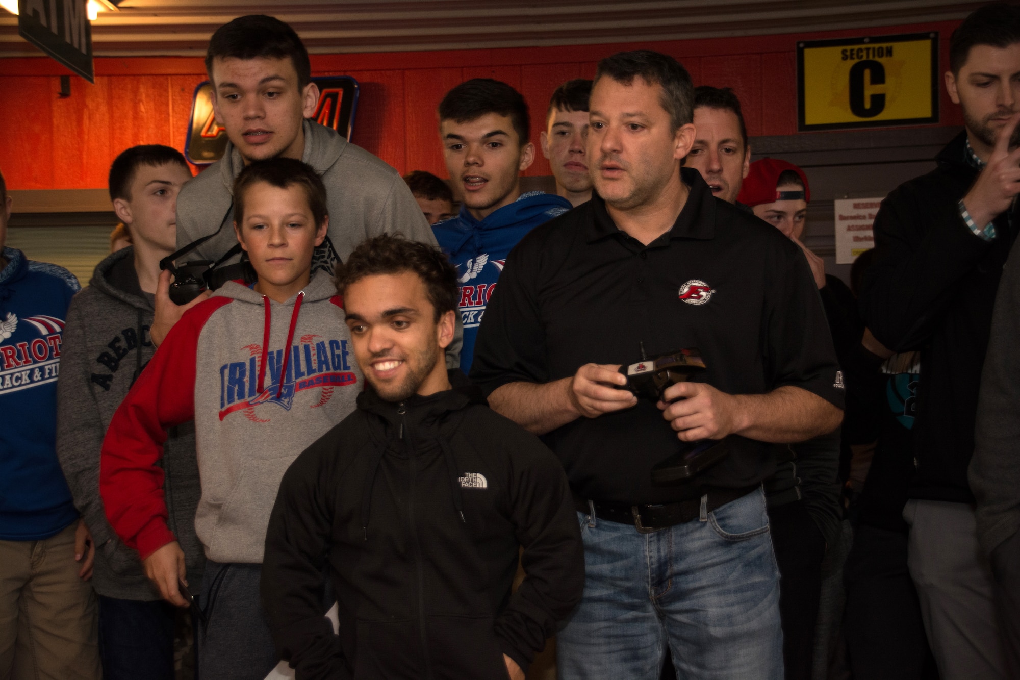 NASCAR driver Tony Stewart uses a remote to control an RC car while fellow driver Rico Abreu and a group of local high school students look on during the Full Throttle STEM® at Eldora Day May 10 at Eldora Speedway in Rossburg, Ohio. (U.S. Air Force photo/Richard Eldridge)